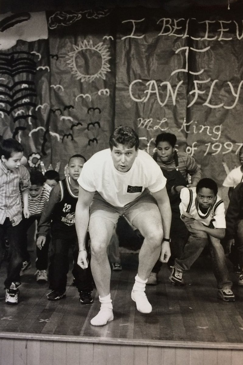 Discover Dance's first director, Phil Otto, dances onstage with a class of elementary school students.