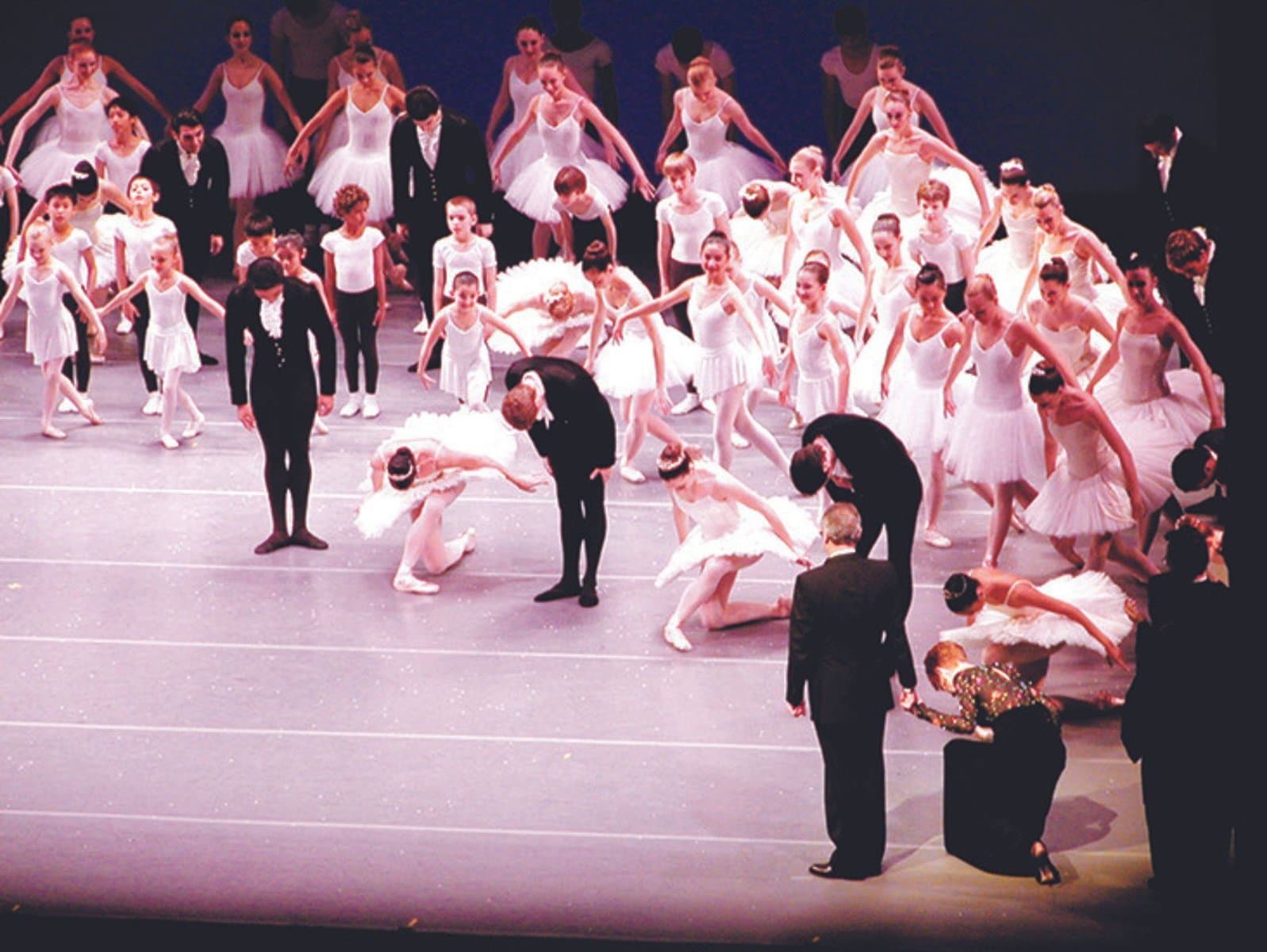 2005.TributePerformance On stage, a large group of ballet dancers and students, dressed in black and white, bow towards Kent Stowell and Francia Russell. Francia is in a deep curtsy.