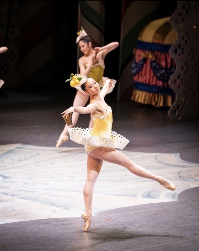 Melisa Guilliams on stage in a yellow leotard and white tutu as marzipan.