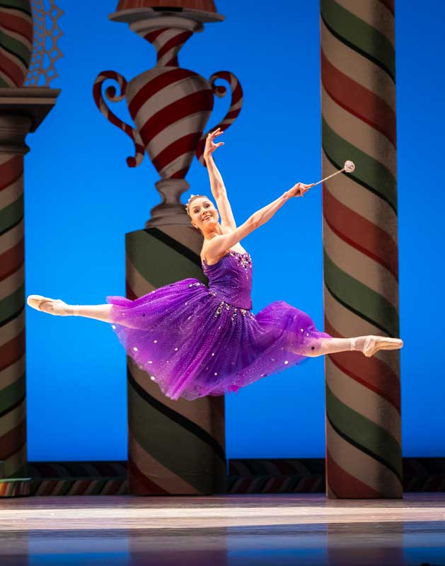 Cecilia Iliesiu leaps across stage as the Sugar Plum Fair in a glittering purple tutu.