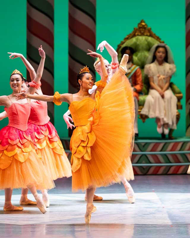 Yuki Takahashi kicks her leg to the side on stage, wearing a long yellow tutu.