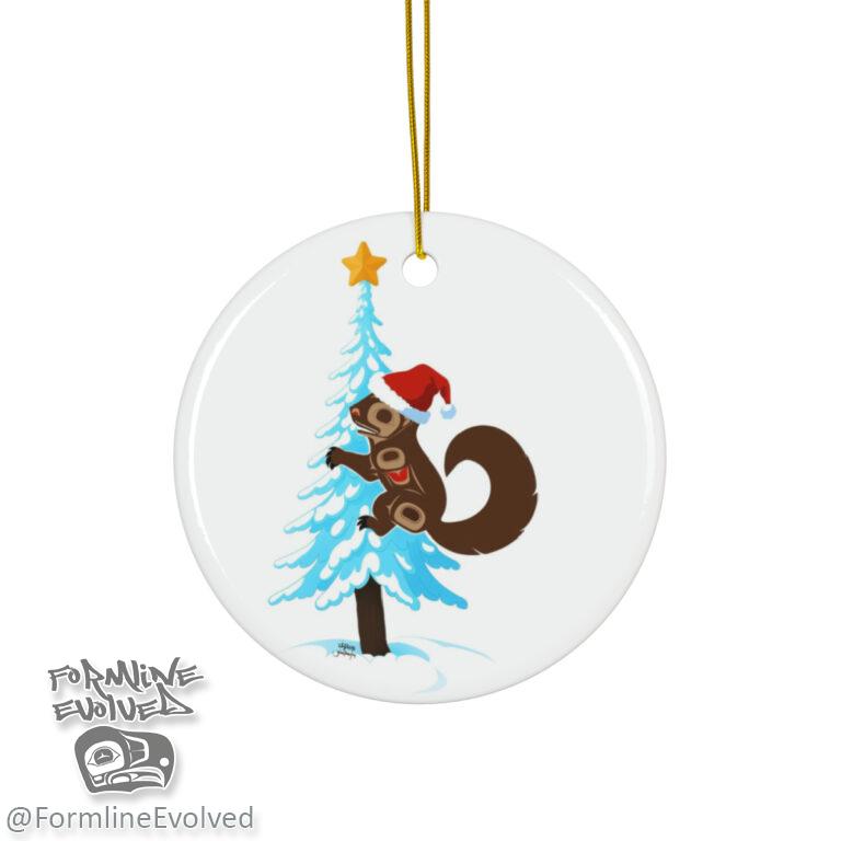 A round glass ornament featuring a formline squirrel wearing a Santa hat and hugging a tree.