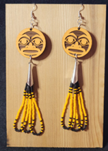 Northwest Dine earrings featuring formline art on cedar dangling above several beaded loops.