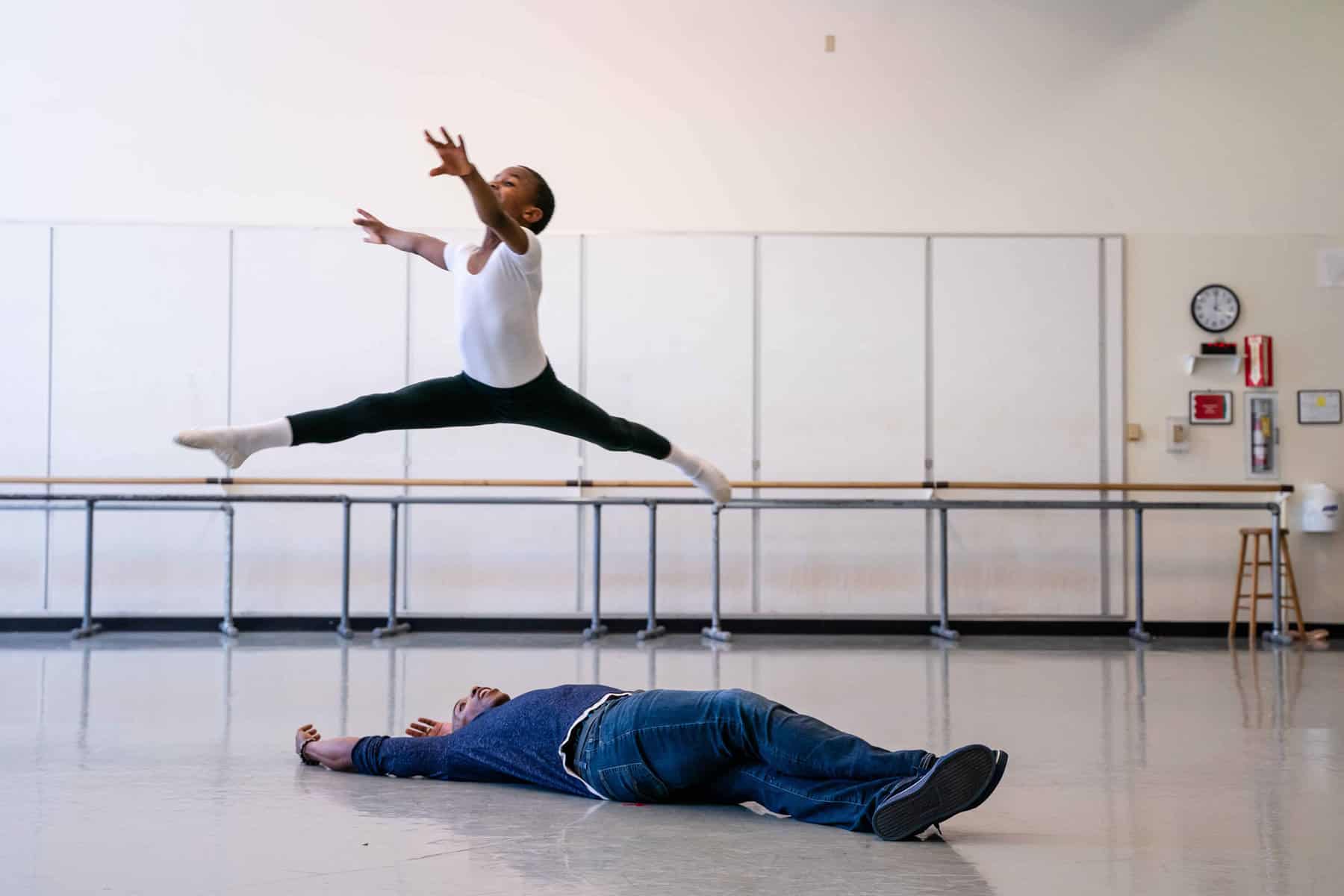 DanceChance student leaping over teacher, Kiyon Ross.