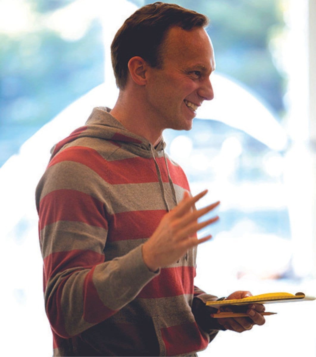PeterBoalinRandJRehearsal A young Peter Boal in a red and grey striped sweatshirt grins as he gives rehearsal notes.